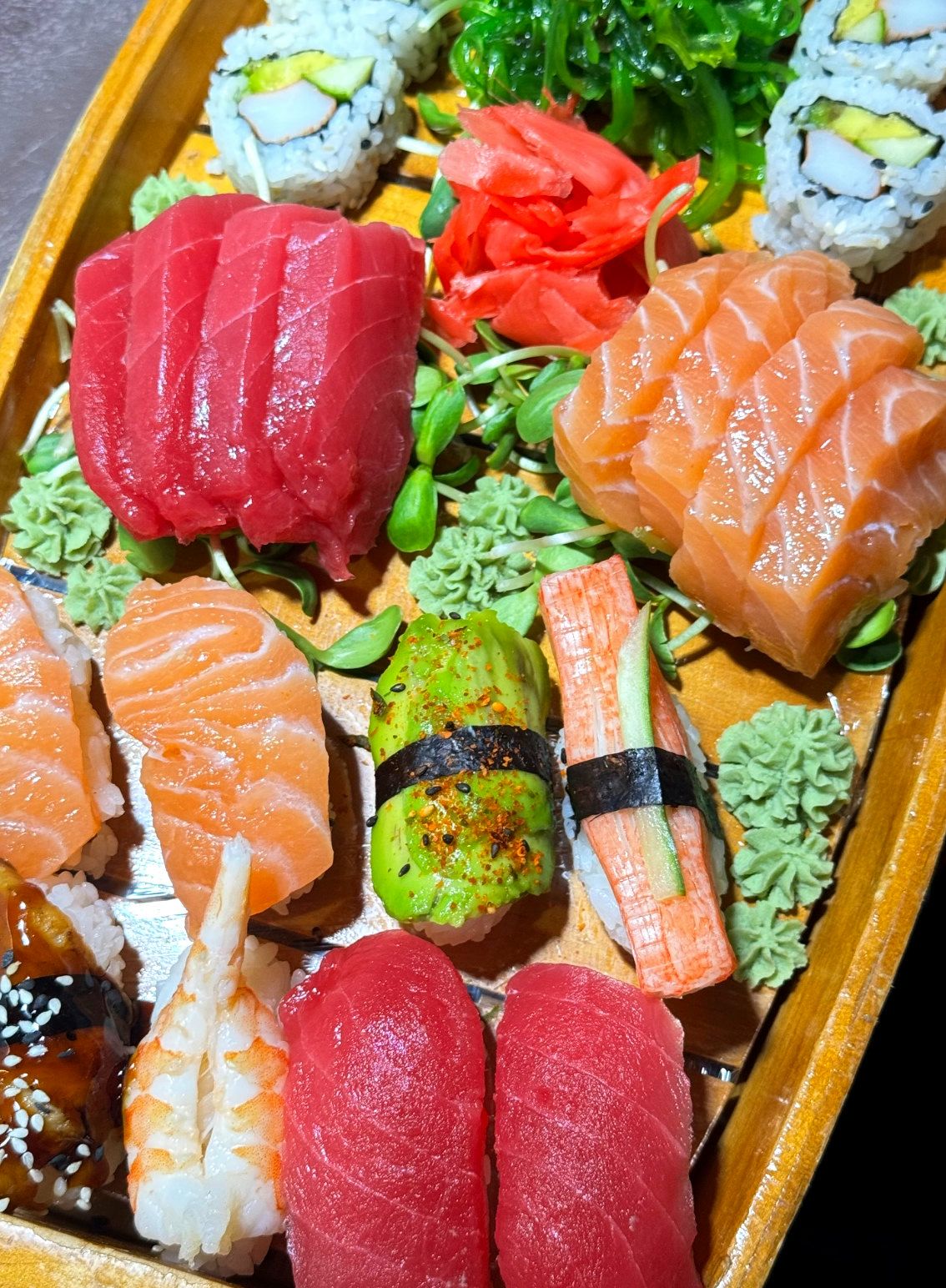 Sushi and sashimi combination boat with tuna, salmon, shrimp and maki rolls